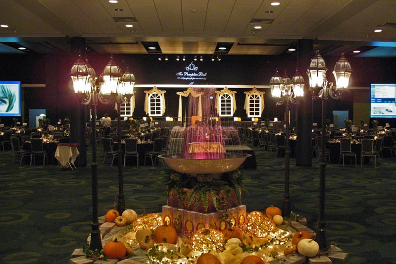 A fountain, pumpkins and decorative street lamps form an autumn reception centerpiece.