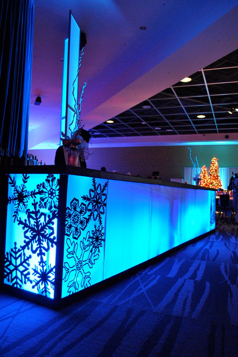 A blue illuminated bar with snowflake panels and matching winter décor.