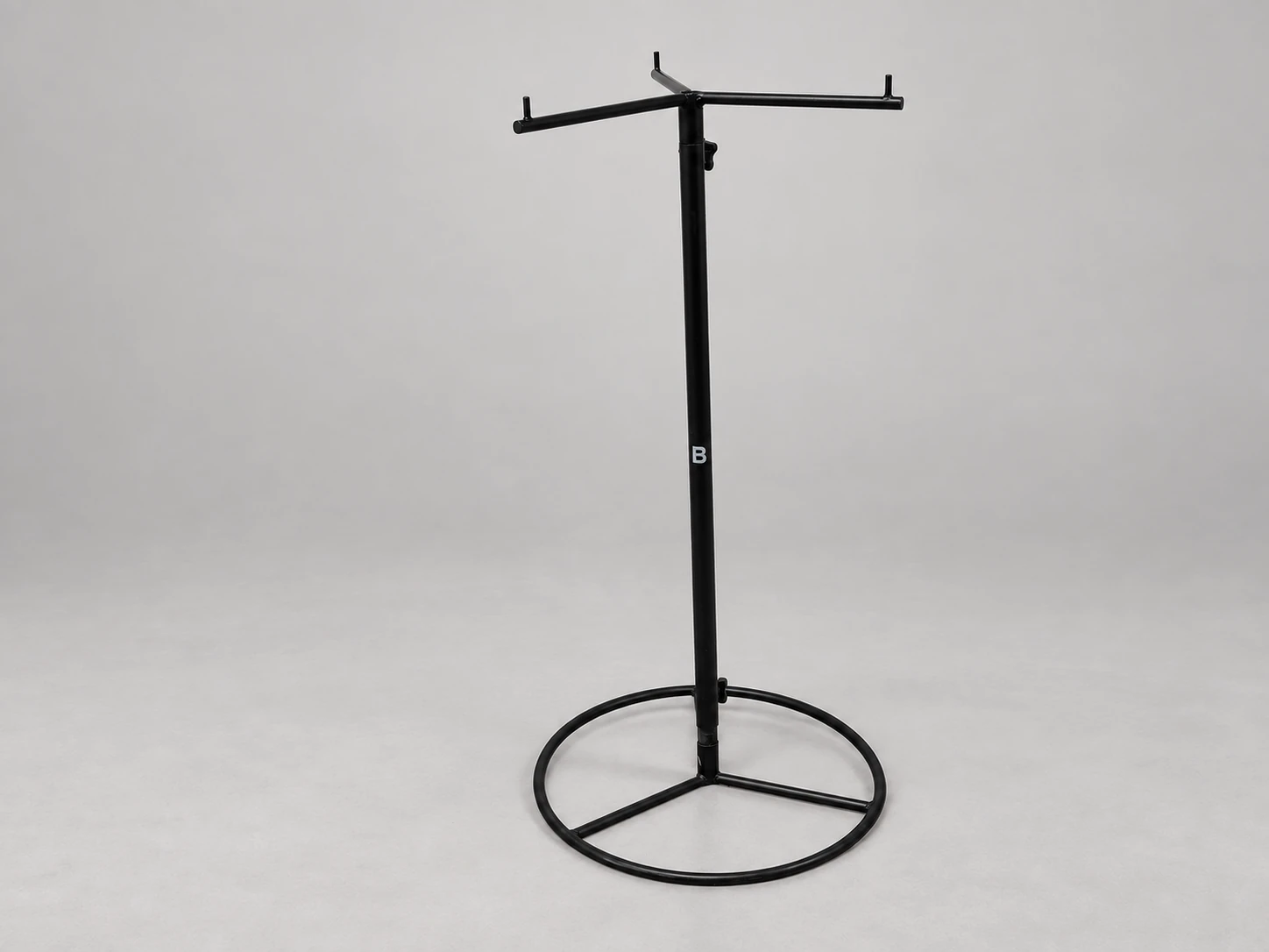 Black three-arm bag stand with upturned hooks, an adjustable pole and an open circular base.