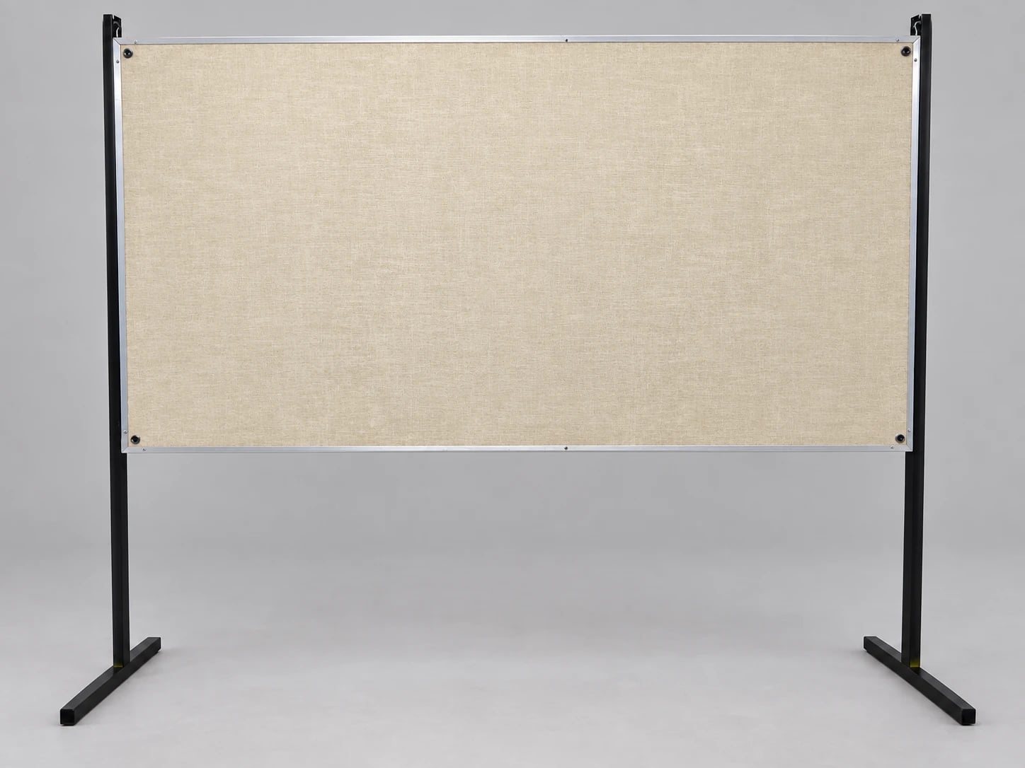 A beige fabric poster board with a silver frame supported by two black uprights with T-shaped feet.